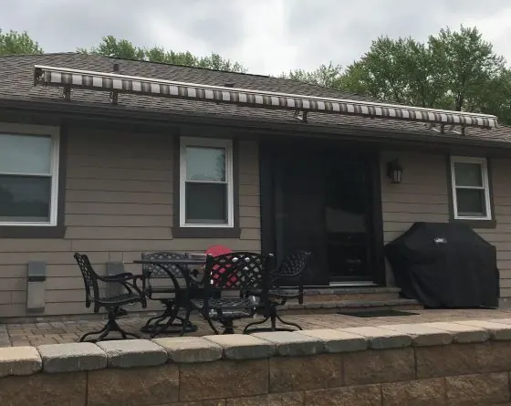 Retractable patio cover fully extended over a shaded Kansas City outdoor living space on a hot afternoon